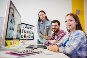 Employees looking at photos on desktop computer
